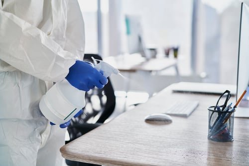Sanitising equipment disinfecting a bright office workspace