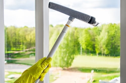 Squeegee cleaning an interior window to a streak-free finish